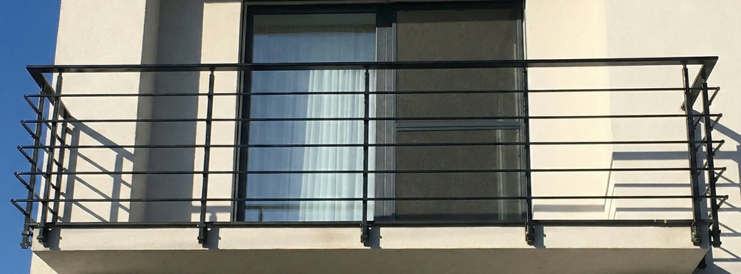 Cerne hlinikove zabradli na balkon na moderni fasade.